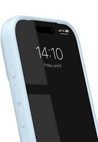 Smarttelefon med lyseblå deksel som viser klokkeslett 14:10 og dato fredag 6. juni på en svart skjerm med 5G-signal og batteriikoner.