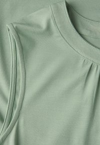 Light green sleeveless top made of soft fabric, featuring a round neckline and subtle pleats for added detail. Smooth texture and tailored fit.
