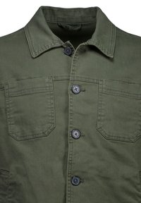 Chaqueta verde oliva abotonada, con cuello clásico, dos bolsillos en el pecho y tela texturizada. Los botones son oscuros y redondos.