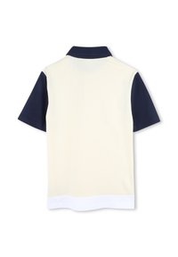 Πόλο μπλουζάκι με κρεμ σώμα και ναυτικές μανσέτες, με λευκή ραφή. Κατασκευασμένο από απαλό, ελαφρύ ύφασμα. Κλασικός σχεδιασμός γιακά.