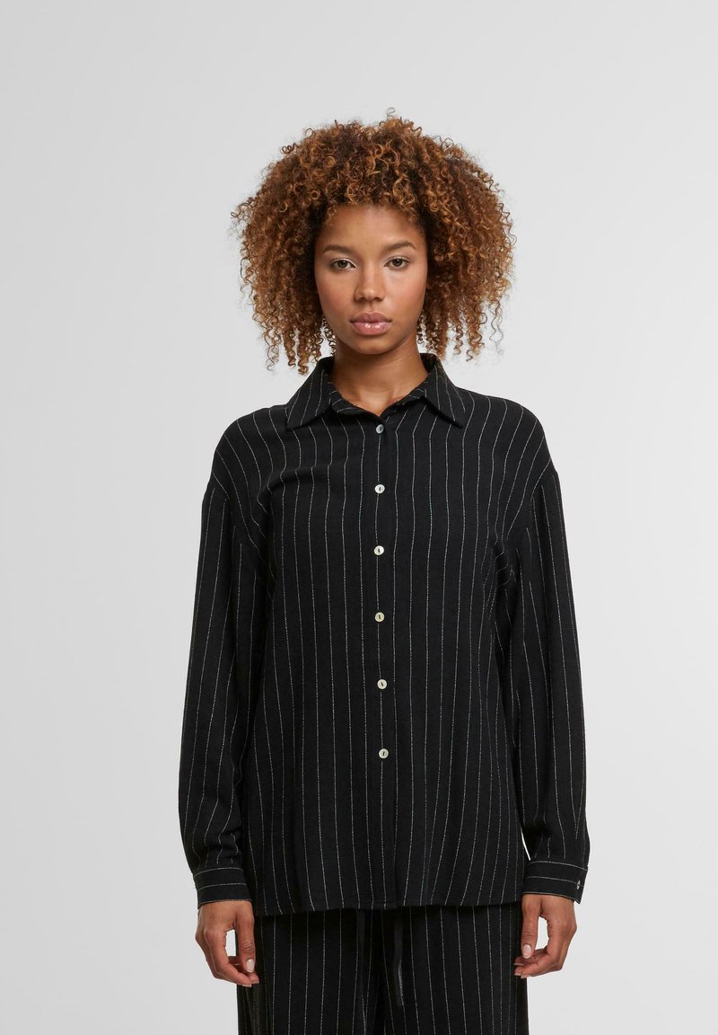Black long-sleeve shirt with white vertical stripes, button-up design, broad collar, and a relaxed fit, made of soft material.