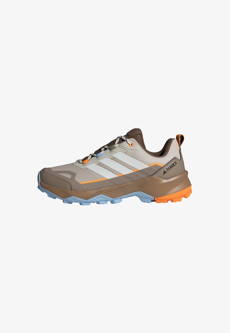 Hellbraune und beige Adidas Terrex Trailrunningschuhe mit orangefarbenen und blauen Akzenten sowie einer robusten Sohle für den Einsatz im Freien.