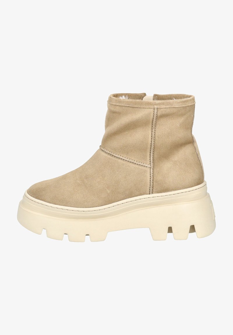 Bota de tobillo de ante beige con punta redondeada, costuras sutiles y una suela gruesa color crema con un patrón de tacos para mejor agarre.