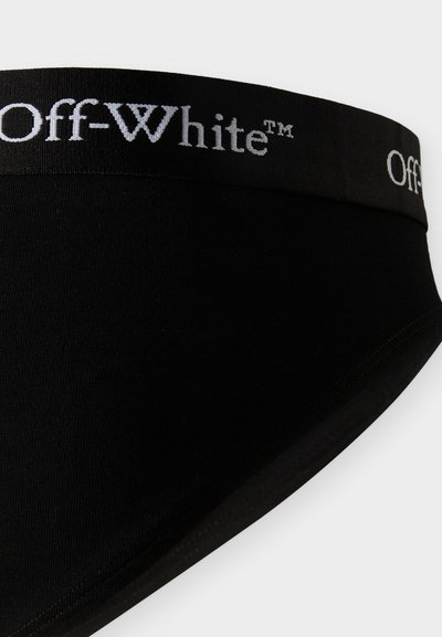 Μαύρα εσώρουχα με μαύρη μέση που φέρει το λευκό λογότυπο "Off-White™" τυπωμένο επανειλημμένα γύρω της.