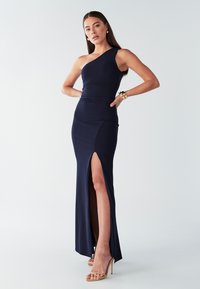Tumši zilas krāsas maxi kleita ar vienu plecu un sānu šķēlumu, izgatavota no elastīga materiāla. Raksturīga pieguļoša krūšu daļa un gluda tekstūra.