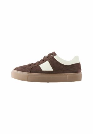 Sneaker bassa in camoscio marrone con accenti in pelle bianca, punta arrotondata, suola piatta e design con lacci. Suola texturizzata per una buona aderenza.