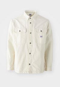 Krämfärgad långärmad skjorta i bomull, med knappstängning fram, två bröstfickor och metallknappar. Lee-logotyp på vänster ficka.