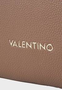 Braune, strukturierten Lederclutch mit einem goldenen, auf der Vorderseite geprägten "VALENTINO"-Logo, das einen Kontrast zum Oberflächendesign bildet.