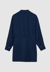 Giacca blu navy a maniche lunghe con cinch in vita, polsini abbottonati, tessuto liscio e colletto semplice. Nessun motivo o accessorio visibile.