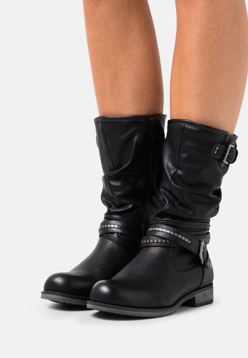 Bottes noires en cuir à la cheville avec un design flou, accent en boucle argentée et sangles décoratives, avec un petit talon et une texture lisse.