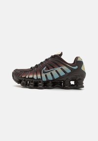 Nike running shoes with a dark brown upper, gradient blue accents, and a glossy black sole featuring springy, stacked air cushioning.