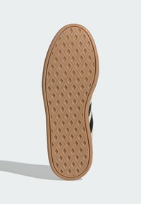 Gumeni potplat cipele s teksturiranim uzorkom saćaste strukture; karakterizira bež boja s uzorcima u obliku dijamanata za bolje prianjanje i vuču.