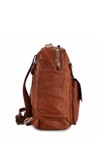 Zaino in pelle marrone con superficie robusta e strutturata, dotato di cerniera superiore e tasca laterale. Tracolla regolabile e dettagli in metallo.