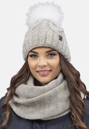 Strikket hue i lys grå med en hvid pompon på toppen; suppleret med et matchende, chunky strikket infinity-scarf.