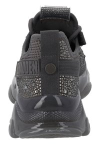 Sort atletik sko med struktureret mesh-overdel, rhinestone-detaljer, gummisål og mærkestofremhævelse ved hælen. Glat, blank detaljer.