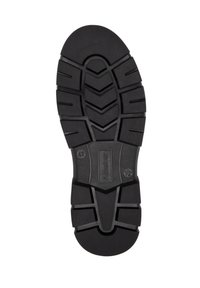 Semelle de chaussure en caoutchouc noir avec une surface texturée, présentant des motifs de bande de roulement profonds et des rainures pour l'adhérence, ainsi qu'un logo central.