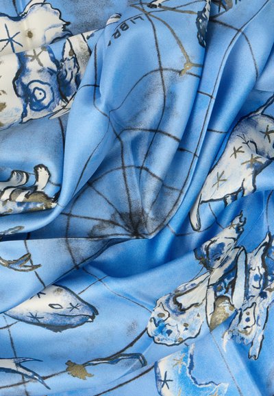 Modrá látka s abstraktnými rybami a námornými motívmi. Materiál pôsobí hladko s jemným leskom, vytvárajúci plynulú textúru.