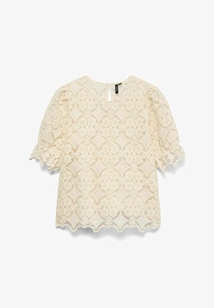 Kreminė nėriniuota palaidinė su pūstomis rankovėmis, gėlių raštu ir banguotu apvadu. Yra rakto skylutės nugaros užsegimas ir tekstūruota medžiaga.