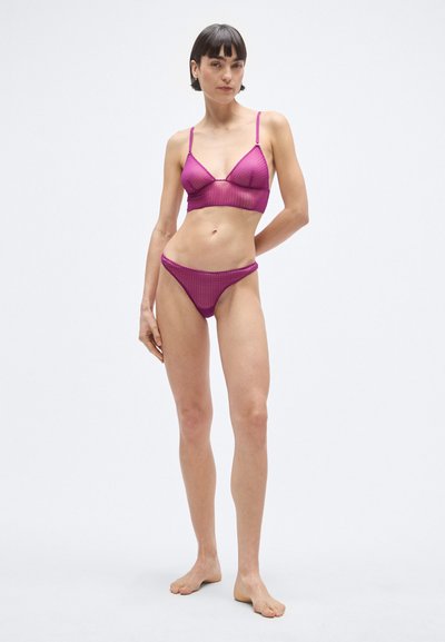 Fukszia színű csipkés bralette vékony pántokkal, háromszög alakú kialakítással, és egy hozzá illő, minimális takarást nyújtó tanga, mindkettő texturált mintával.