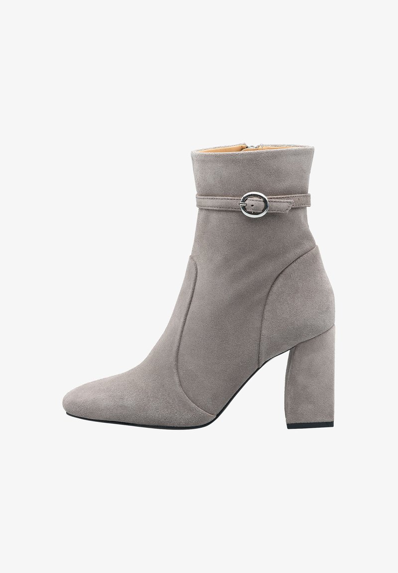 Grijze suede enkelboot met een spitse neus, een ronde gesp om de enkel en een blokhak. Gladde textuur met minimale details.