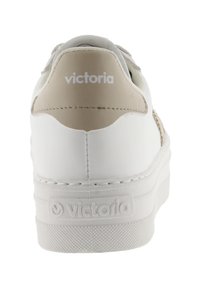 Sneaker bianco con tomaia in pelle liscia, accentuazione beige sul tallone, lacci piatti e suola in gomma testurizzata con logo del marchio sul tallone.