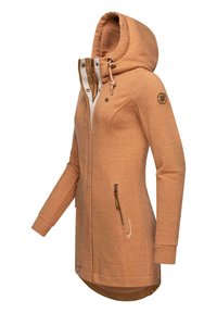 Light brown hooded jacket with a zip front, side pockets, and a curved hem. Features a textured fabric and a circular logo on the sleeve.