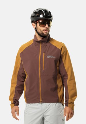 Bordeaux-rote und bernsteinfarbene wasserdichte Jacke mit hohem Kragen, Reißverschlusstasche auf der Vorderseite und elastischen Bündchen. Trägt einen schwarzen Helm und eine Sonnenbrille.