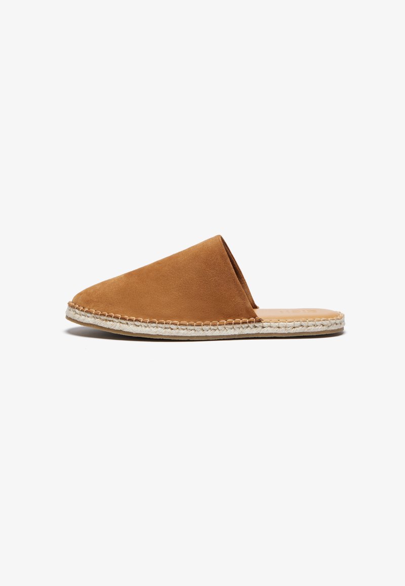 Suede slip-on mule i varm brun med en rund tå, der har en vævet reb-sål og en glat læderindersål. Minimalistisk design.