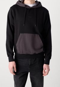 Sudadera con capucha negra y gris con un bolsillo frontal, hecha de una suave mezcla de algodón, que cuenta con cordones ajustables y puños acanalados.
