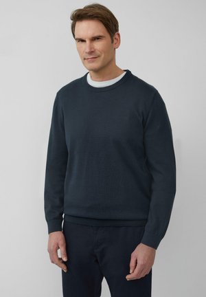 Marineblauwe trui met een ronde hals, geribbelde manchetten en zoom. Gemaakt van gebreide stof; heeft een discreet logo op de borst.