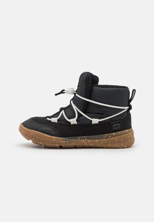 Czarne półwysokie sneakersy z teksturowanego materiału, białym systemem sznurowania i brązową gumową podeszwą w plamy.