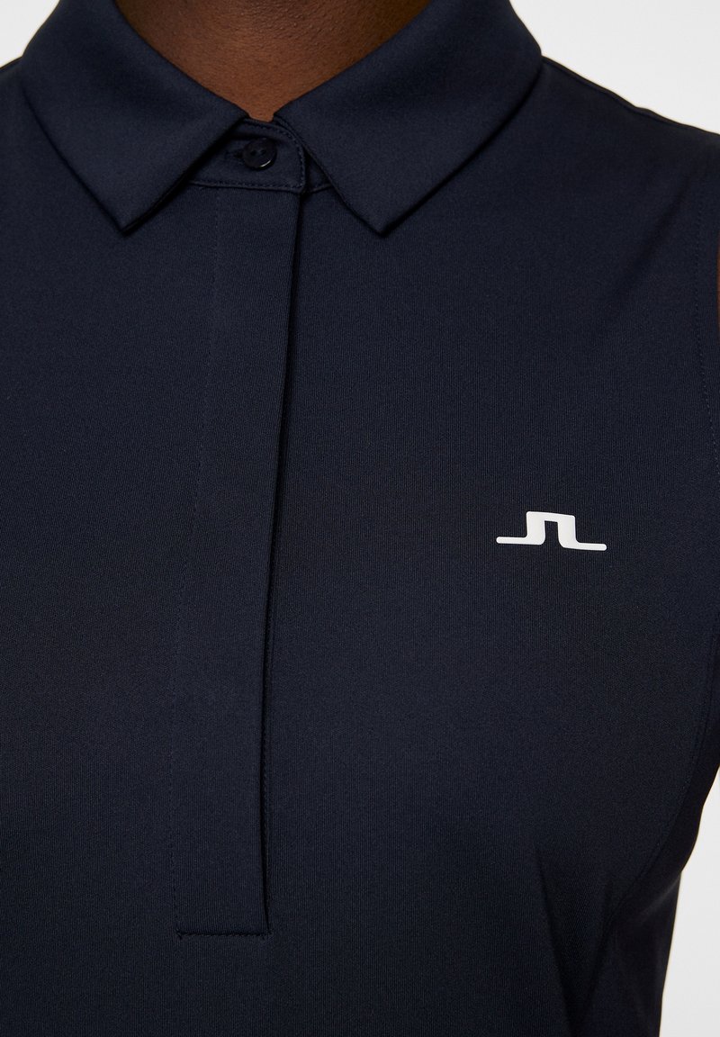 Polo shirt navy con colletto, caratterizzato da un'apertura frontale e un piccolo logo bianco sul petto sinistro. Realizzato in un tessuto liscio ed elastico.