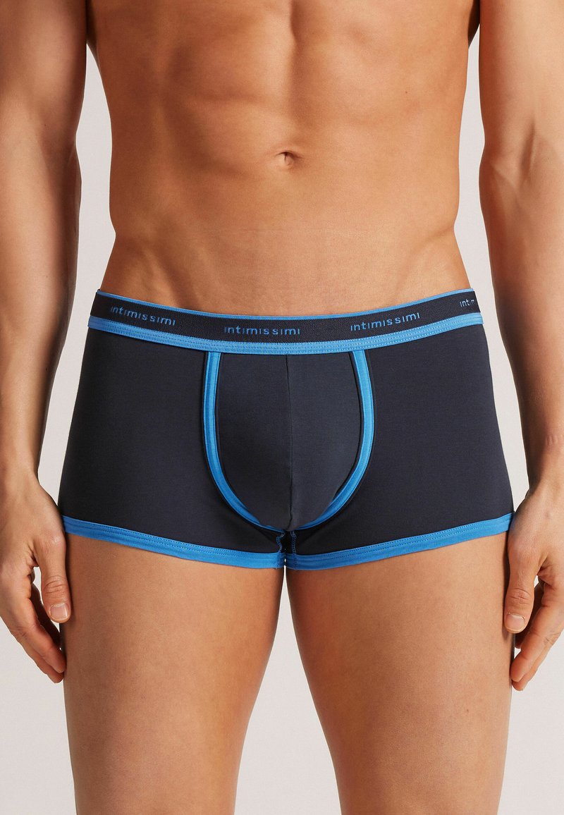 Dunkelblaue Boxer-Shorts mit hellblauem Bund und Akzenten. Sie besitzen ein figurbetontes Design und sind aus weichem Stoff mit einem unterstützenden Vorderteil.