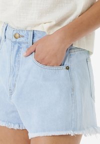 Light blue denim shorts with frayed hem, five pockets, and a metal button closure. Texture appears smooth with a casual fit.