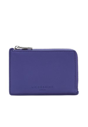 Lila Lederbrieftasche mit glatter Oberfläche, Reißverschluss und geprägtem Markenlogo auf der Vorderseite. Kompaktes, rechteckiges Design.