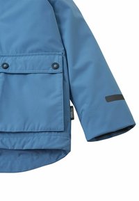 Abbigliamento esterno blu chiaro con una grande tasca frontale, polsini elasticizzati e un'etichetta sull'orlo, che sottolinea funzionalità e stile.