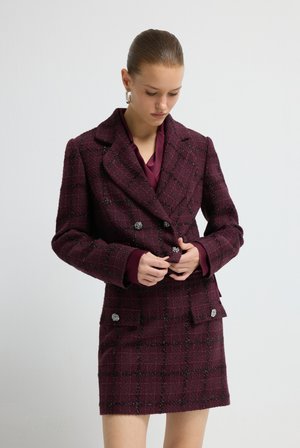 Burgundy rutigt dubbelknäppt blazer med silverknappar, med en texturerad tyg och strukturerad form, parat med en matchande blus.