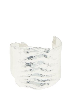 Ampio bracciale in argento con finitura martellata e testurizzata e apertura sul retro per una vestibilità regolabile.