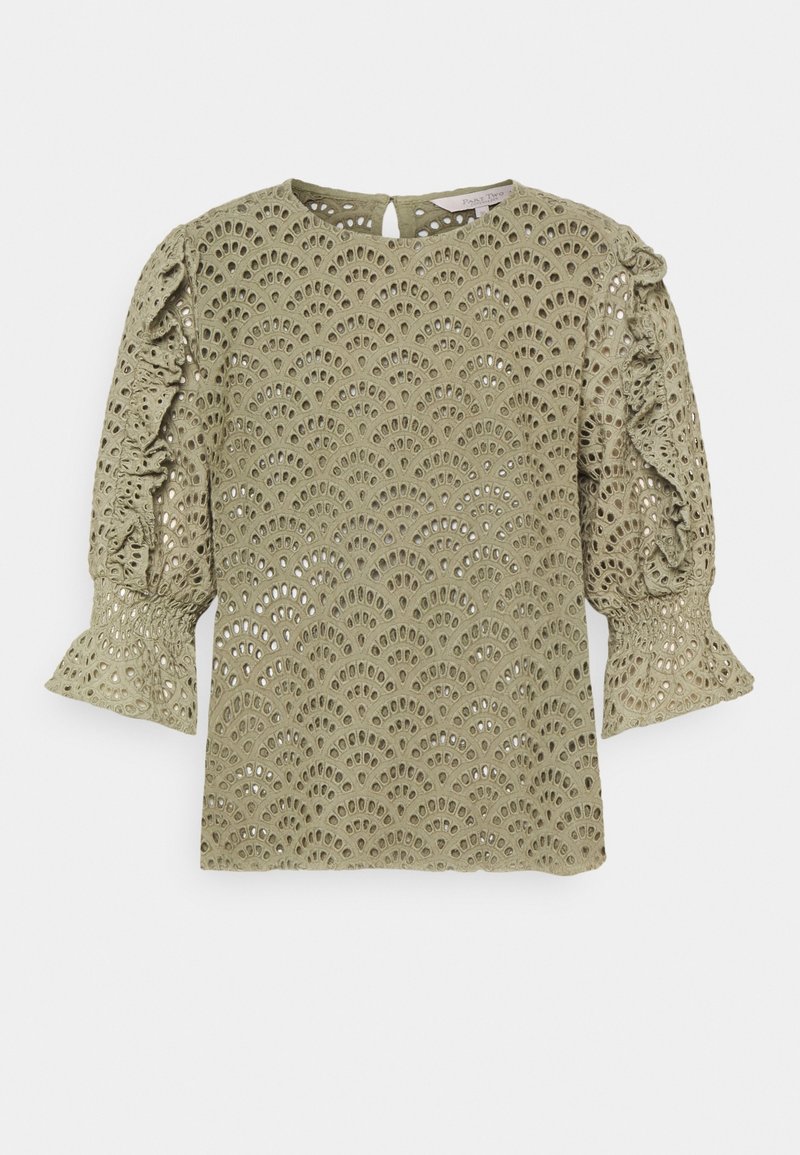 Blouse vert olive avec motif découpé au laser, possédant des manches bouffantes et des accents froncés, un col rond et une fermeture par clé à l'arrière.