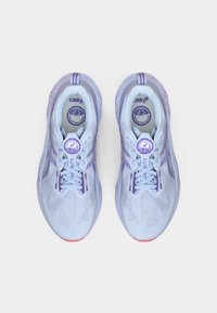 Adidași de culoare albastru deschis cu accente mov, suprafață texturată și talpă de culoare roz. Au un design cu șireturi și un logo circular pe limbă.
