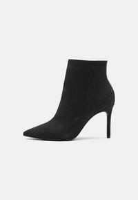 Botines negros con punta afilada, fabricados en tejido texturizado. Presentan un tacón de aguja y una silueta elegante y estilizada.