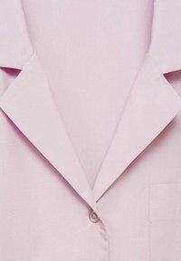 Blazer rosa chiaro con colletto a punta, chiusura con un solo bottone e taschino sul petto; realizzato in tessuto morbido con un design essenziale.