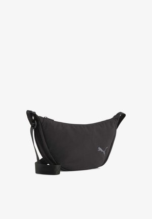 Sac bandoulière en tissu noir à forme incurvée, avec une sangle ajustable et un discret logo gris. Fermeture zippée sur le dessus.