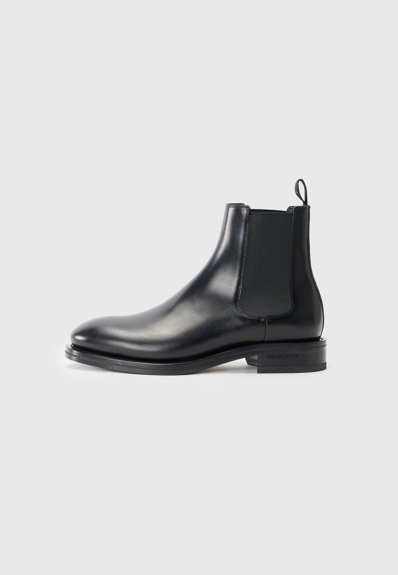 Black leather Chelsea boot featuring a sleek design, elastic side panels, rounded toe, and a low, stacked heel.