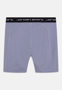 Shorts de sport violets avec une ceinture élastique noire portant le texte "jordan sport." Texture lisse avec des coutures plates et un design ajusté.