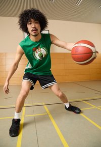 Πράσινη αμάνικη φανέλα με το λογότυπο των Celtics, μαύρες σορτς με λευκές ρίγες και μαύρα παπούτσια μπάσκετ. Εσωτερικό γήπεδο με κίτρινες γραμμές.