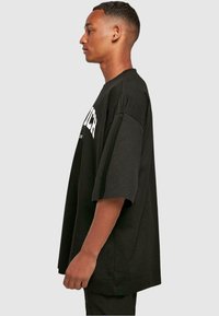 Merchcode MUNICH WORDING - HUGE TEE - Trükipildiga T-särk - black