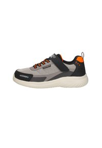 Zapatilla deportiva de malla gris con acentos negros, detalles naranjas, asegurada con cordones y una correa, con una suela texturizada para mayor agarre.