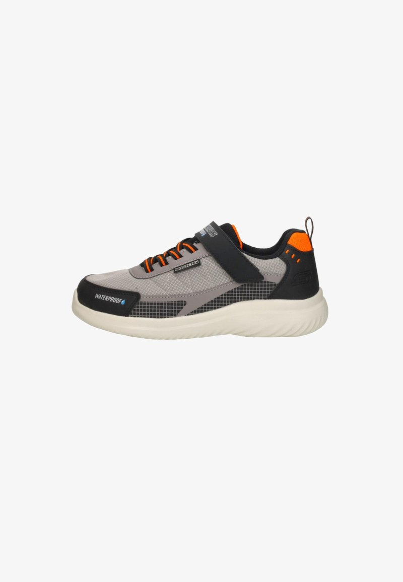 Zapatilla deportiva de malla gris con acentos negros, detalles naranjas, asegurada con cordones y una correa, con una suela texturizada para mayor agarre.