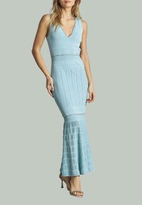 Hellblaues Strickkleid mit V-Ausschnitt, figurbetontem Oberteil, strukturierten Mustern und ausgestellt geschnittenem Saum. Akzentuiert mit einem Schmuckbund.